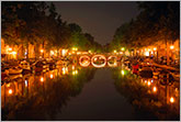 Amsterdam canal and bridge at night with beautiful lights and reflections